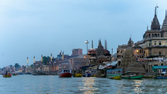 Promo,Explore the vibrant ghats of Varanasi along the Ganges River, India, with colorful boats and historic temples.